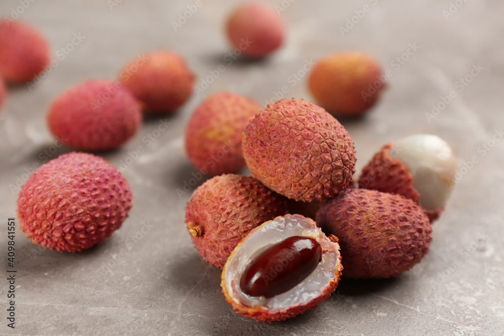 Fresh ripe lychee fruits on grey table Fresh ripe lychee fruits on grey table