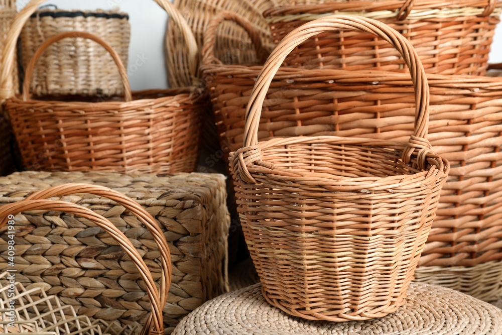 Many different wicker baskets made of natural material as background, closeup