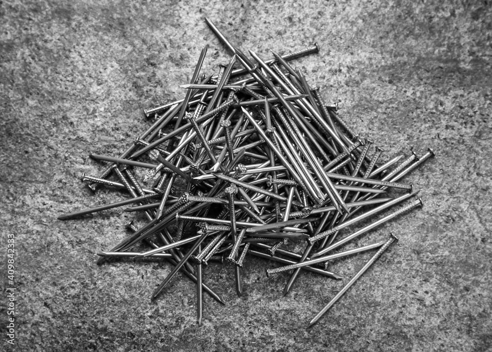 Many metal nails on grey background, flat lay Many metal nails on grey background, flat lay