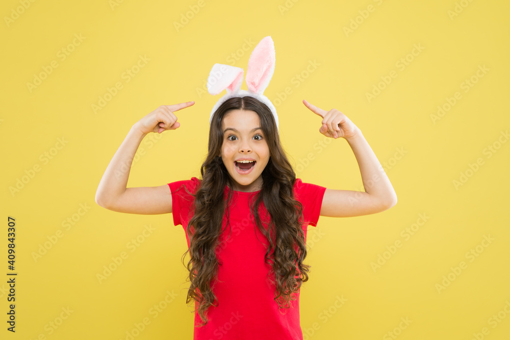Getting ready for Easter. portrait of a pointing child. having fun. funny kid wear bunny ears. girl in Easter ears during egg hunt. holiday and child concept. spring family holiday. little cute bunny Getting ready for Easter. portrait of a pointing child. having fun. funny kid wear bunny ears. girl in Easter ears during egg hunt. holiday and child concept. spring family holiday. little cute bunny