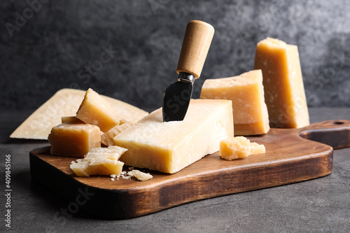 Parmesan cheese with knife on grey table