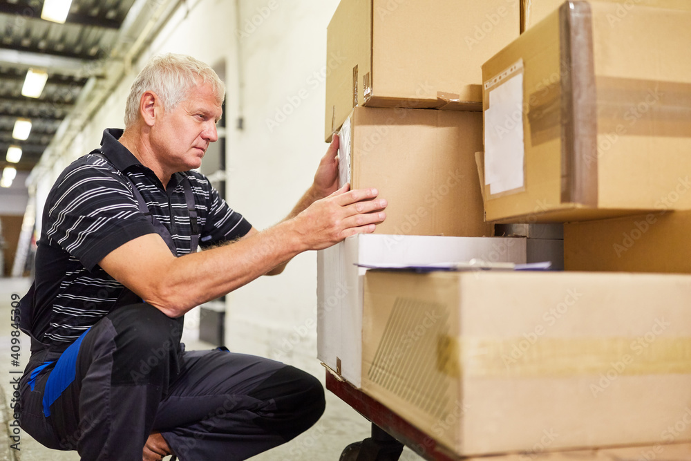 Lagerist im Warenlager kontrolliert Pakete Stock Photo Adobe Stock