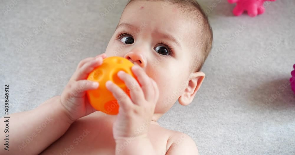 infant, childhood concept - close-up of smiling happy Baby plays with a teether. Teeth cutting. First teeth. Joy toothless 7 months baby bite, gnaws teether toy infant, childhood concept - close-up of smiling happy Baby plays with a teether. Teeth cutting. First teeth. Joy toothless 7 months baby bite, gnaws teether toy