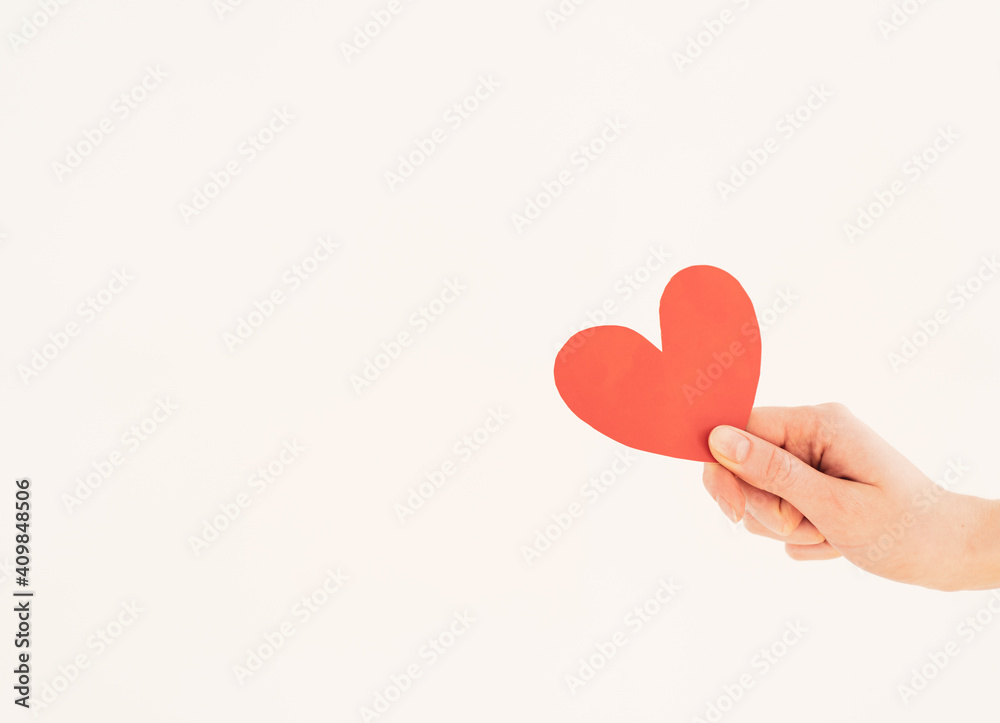 Red paper valentine in a woman's hand on a white background. Valentine's Day Red paper valentine in a woman's hand on a white background. Valentine's Day