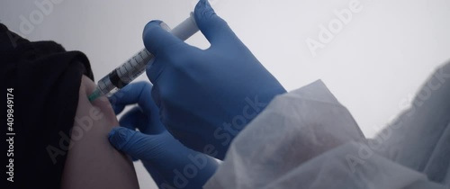 Hand injecting a vaccine to a man arm