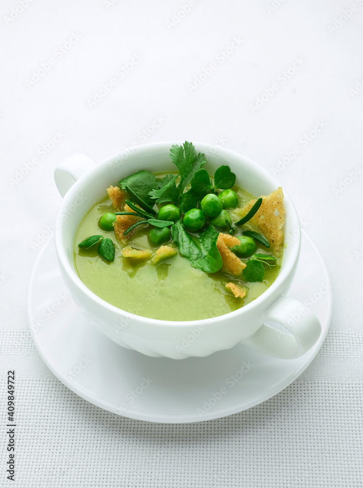 Green pea puree soup on white plate with place for text Green pea puree soup on white plate with place for text