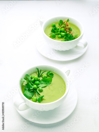 Green pea puree soup on white plate with place for text