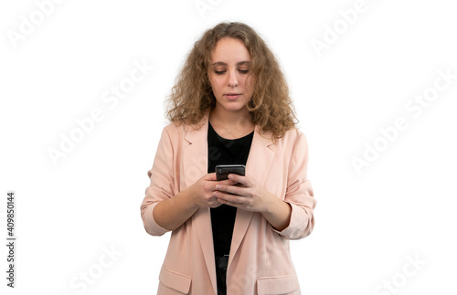 Business woman in a suit is typing with her phone, isolated on white background.