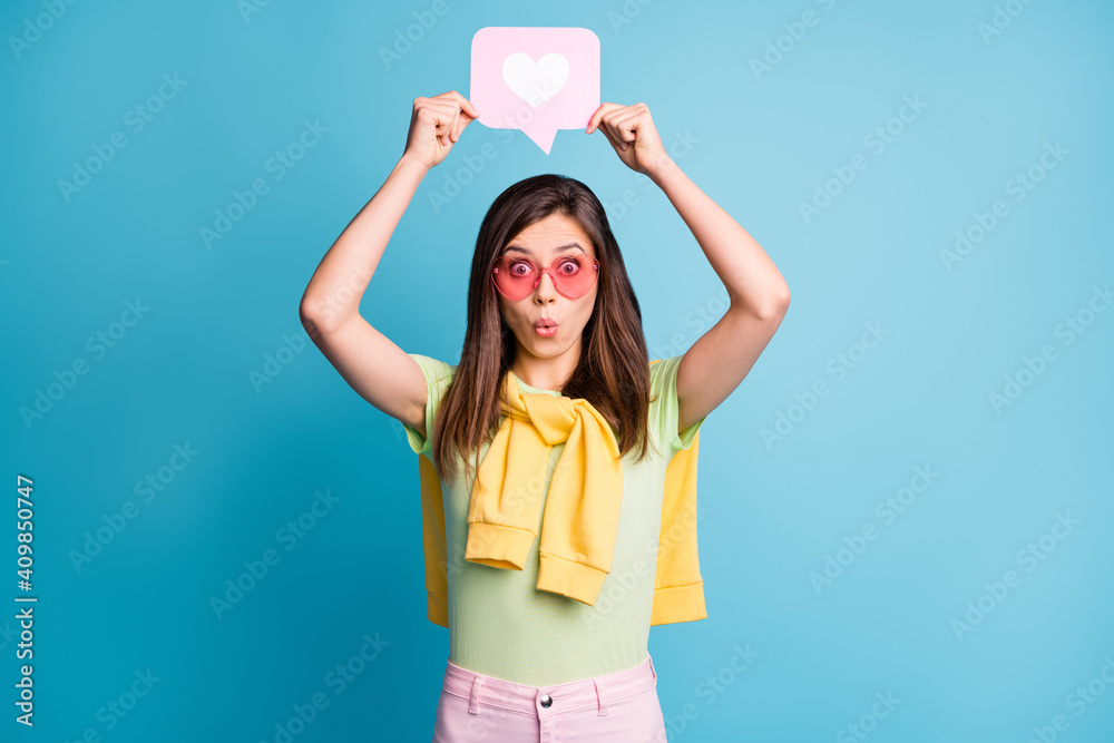 Photo of pretty person hold heart paper above head pink sunglass tied on shoulders sweater isolated on blue color background - obrazy, fototapety, plakaty 