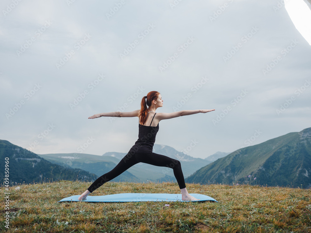 Woman practices yoga on a rug outdoors in the mountains fresh air tourism Woman practices yoga on a rug outdoors in the mountains fresh air tourism