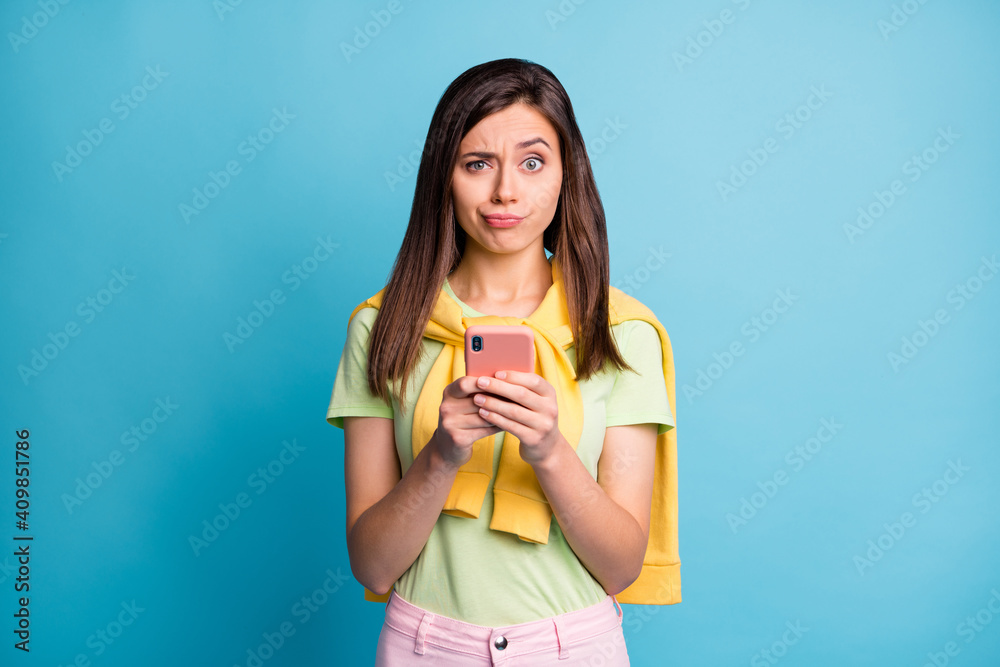 Portrait of attractive skeptic girl using gadget smm browsing media dislike indifferent isolated over bright blue color background Portrait of attractive skeptic girl using gadget smm browsing media dislike indifferent isolated over bright blue color background