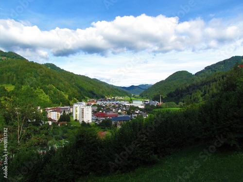 View of small town of Zelezniki in Selska dolina in Gorenjska region of Slovenia surrounded by forest covered hills