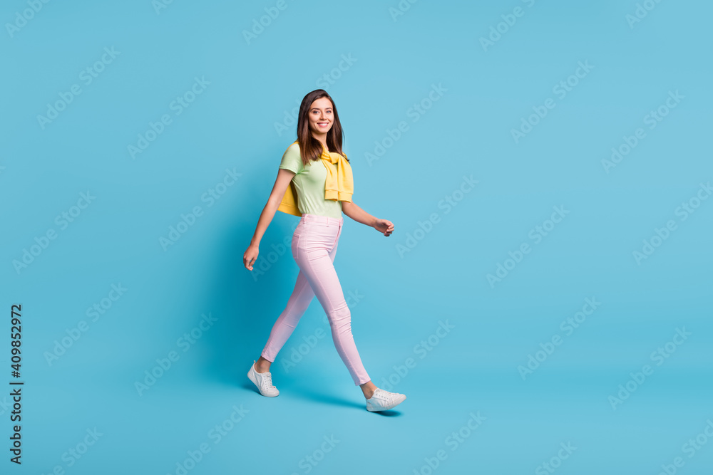 Full length body size view of attractive cheerful girl wearing casual look strolling pastime isolated over bright blue color background