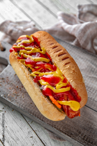 Hot dog with ketchup and mustard  for take away or food delivery on wooden background.