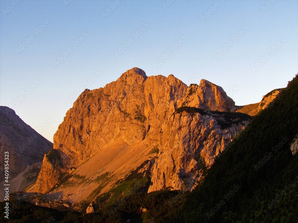 iew of mountain Vernar at sunrise lit by sunlight in Julian alps, Slovenia