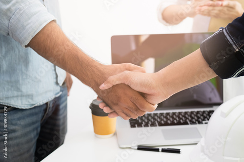 Close up hand of group, team young contractor, engineer handshake with partnership, customer after agreement to work together at the site, workplace, office. Business success concept.
