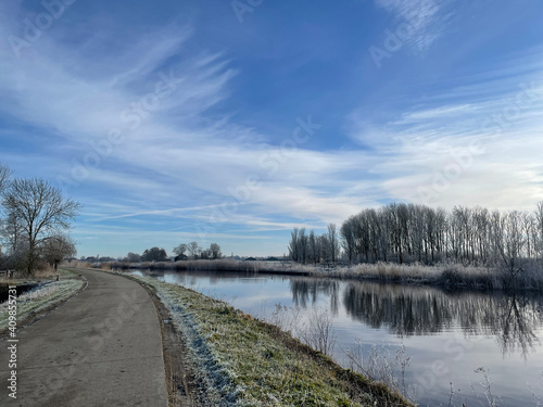 Road next to a canal around Nes during a winter day © TravelTelly