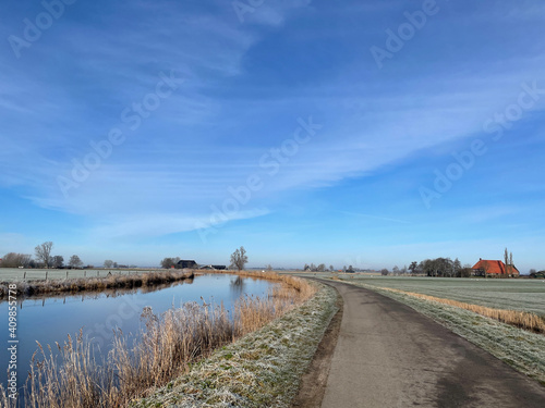 Road next to a canal around Aldeboarn during a winter day © TravelTelly