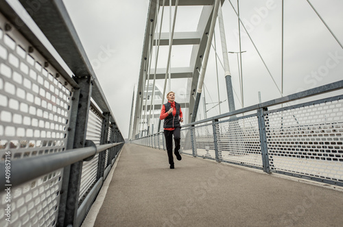 Active senior woman running through the city during the day. © Zoran Zeremski