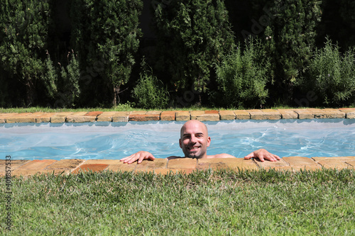 handsome guy half-naked cheerful man smiling laughing in blue water swimming pool