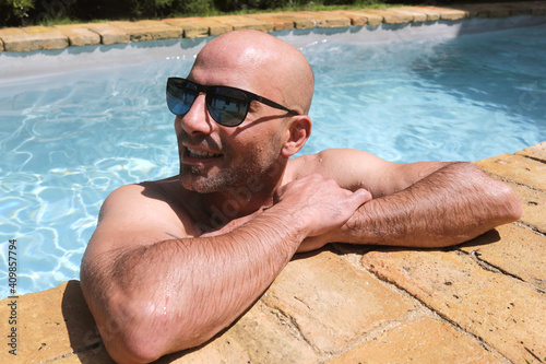 handsome guy half-naked cheerful man smiling laughing in blue water swimming pool