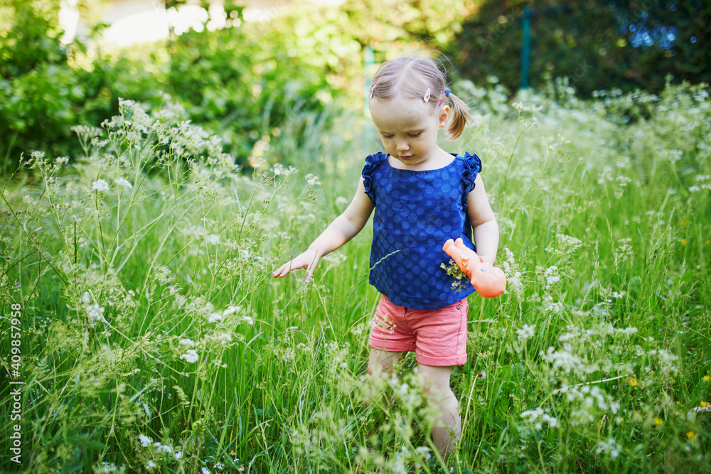 Adorable toddler girl walking in park or forest Adorable toddler girl walking in park or forest