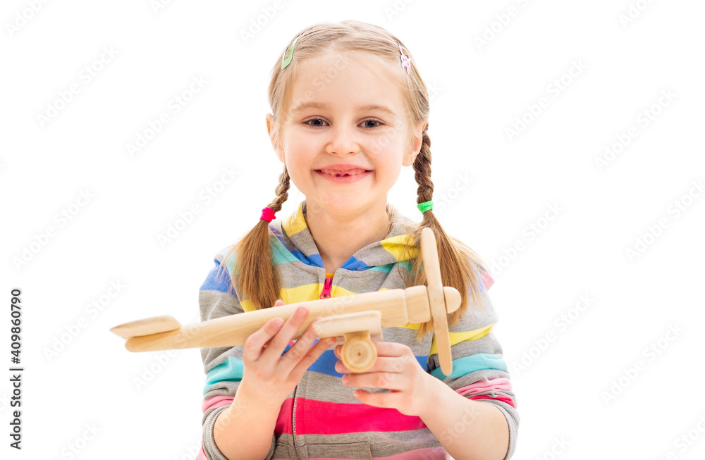Beatiful smiley girl playing with old-fashioned wooden toy plane isolated on a white background Beatiful smiley girl playing with old-fashioned wooden toy plane isolated on a white background