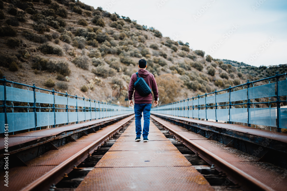 Young man on train track bridge Young man on train track bridge