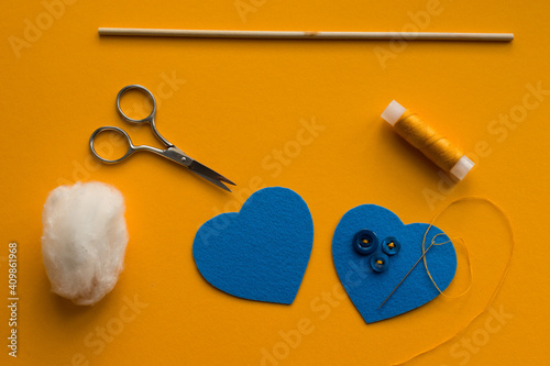 Step 4, making a valentine from blue felt with your own hands (DIY): we sew buttons to one of the heart details in a chaotic manner. photo