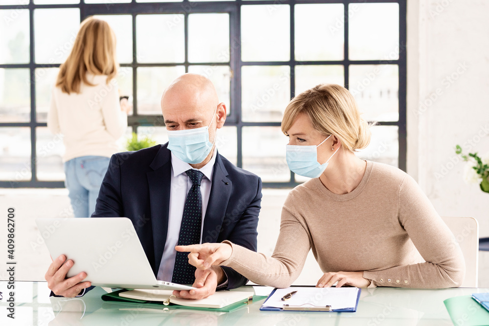 Group of business people working together in the office while wearing face masks for prevention Group of business people working together in the office while wearing face masks for prevention