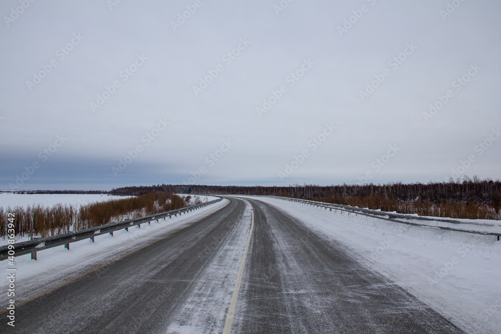 Winter track in the North. Two-lane track with bumpers, fences, snow and ice. Winter track in the North. Two-lane track with bumpers, fences, snow and ice.