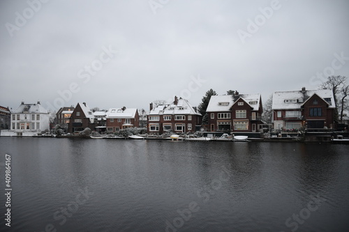 Snow-covered houses in the Dutch city of Haarlem across the Spaarne river in winter. 