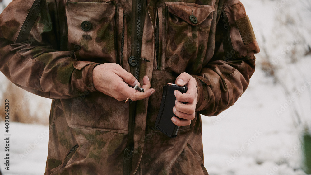Uniform shooter loads 5.45mm rounds into the magazine for the Kalashnikov assault rifle