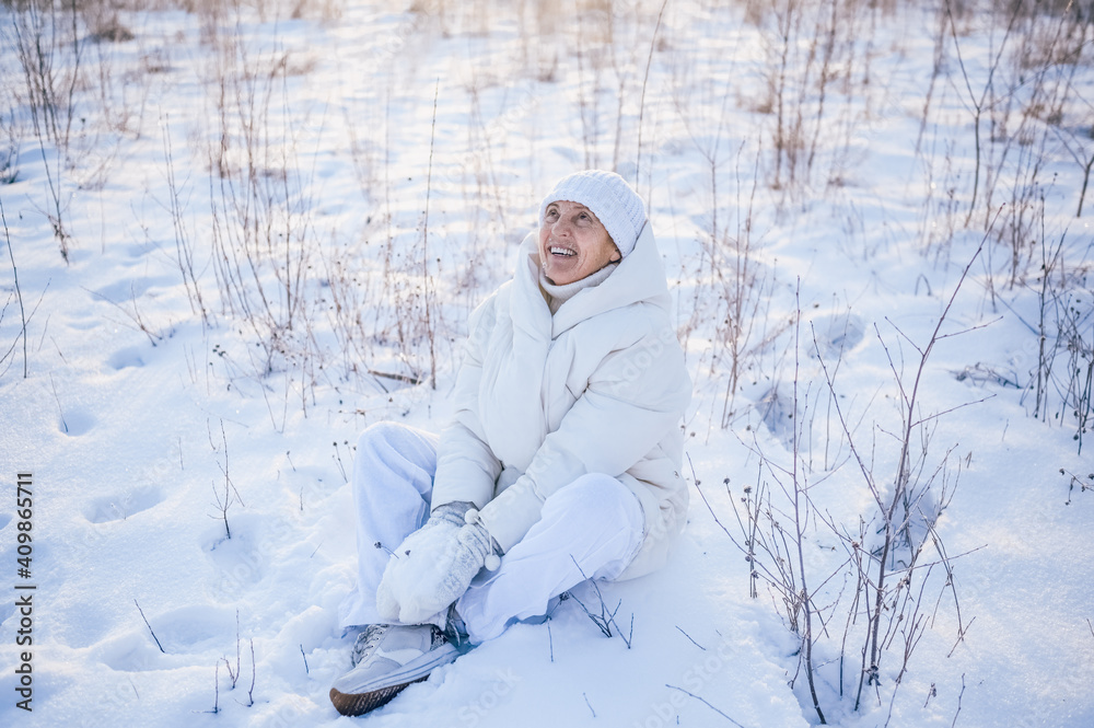 Happy elderly senior mature woman in white warm outwear playing with snow in sunny winter outdoors. Retired healthy people holiday vacation winter activities, active lifestyle concept. Happy elderly senior mature woman in white warm outwear playing with snow in sunny winter outdoors. Retired healthy people holiday vacation winter activities, active lifestyle concept.