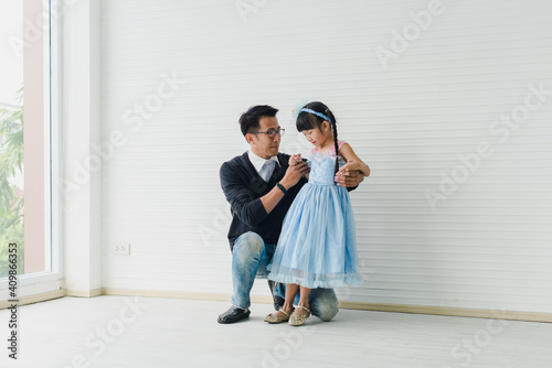 An Asian father and daughter are dancing, dad teaches daughters to dance in a fun room