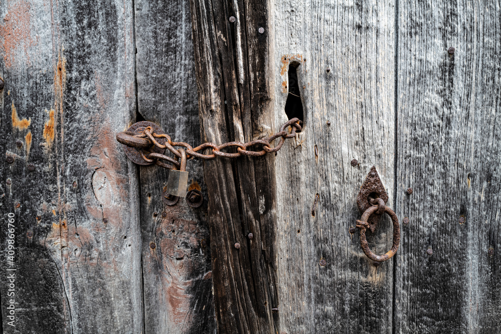 porte en bois vérouillée avec une chaine et un cadenas