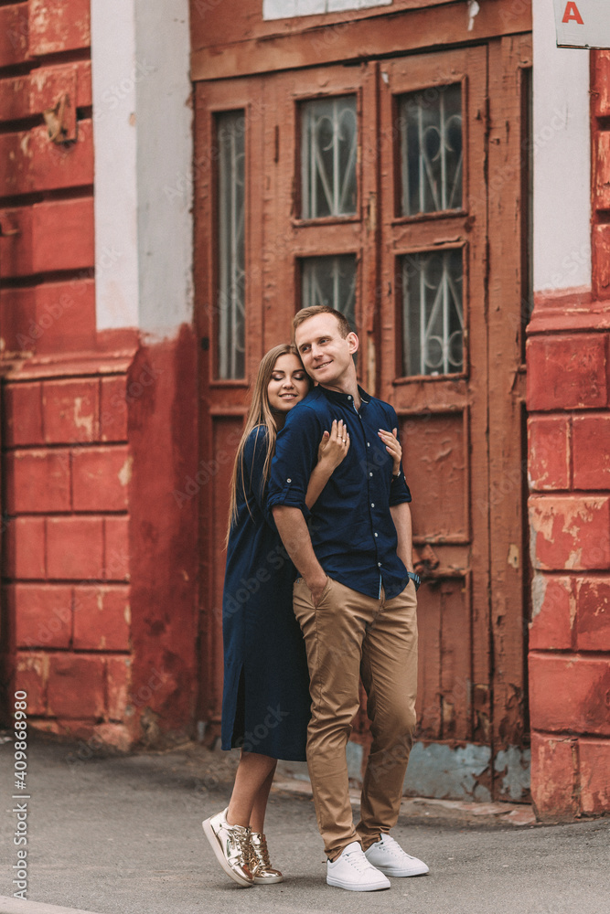 Happy beautiful young couple on the background of red old doors. Happy family concept Happy beautiful young couple on the background of red old doors. Happy family concept
