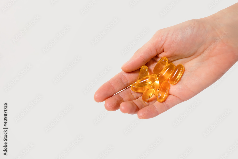 Capsules of fish oil in the palm of a person on a white background. A physician's recommendation for using fish oil as a dietary supplement to improve cardiovascular health. Free space for text Capsules of fish oil in the palm of a person on a white background. A physician's recommendation for using fish oil as a dietary supplement to improve cardiovascular health. Free space for text