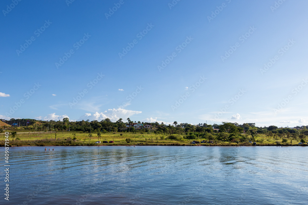 Lago sob céu azul e cercado por vegetação. Lago sob céu azul e cercado por vegetação.