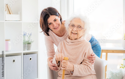 Valokuva Happy elderly woman embraced by daughter at home