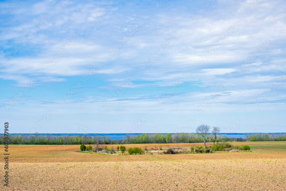 Rural landscape view at a field and a lake in the backgrounds