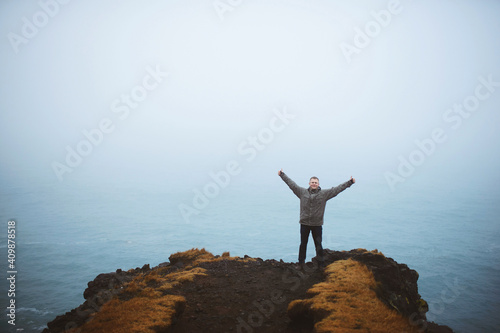 man on top of mountain at sea