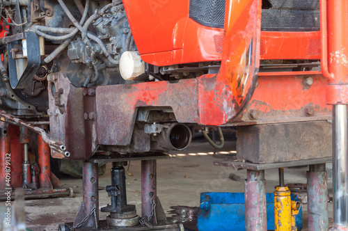 Jack is lifting the car to perform various repairs on the tractor.