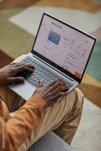 High angle view at African-American man using laptop with banking service on screen, copy space