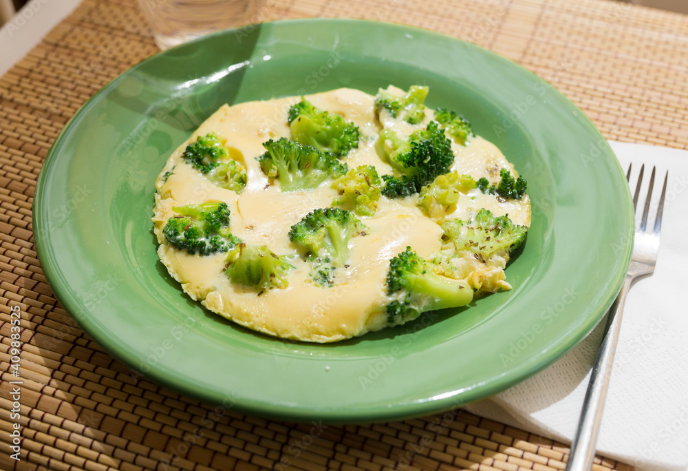 wholesome breakfast. omelet with broccoli on green plate