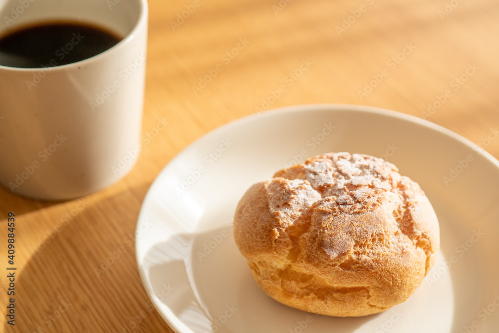 A cream puff and a cup of coffee