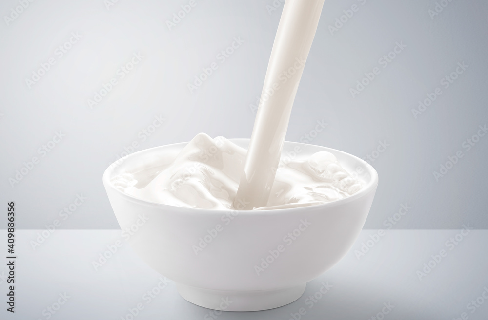 Fresh milk pouring in bowl with splash. isolated on grey and white background. Fresh milk pouring in bowl with splash. isolated on grey and white background.