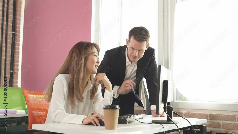 Polite director gives directions and advice to his employee working at the computer in the office, successful team. Polite director gives directions and advice to his employee working at the computer in the office, successful team.