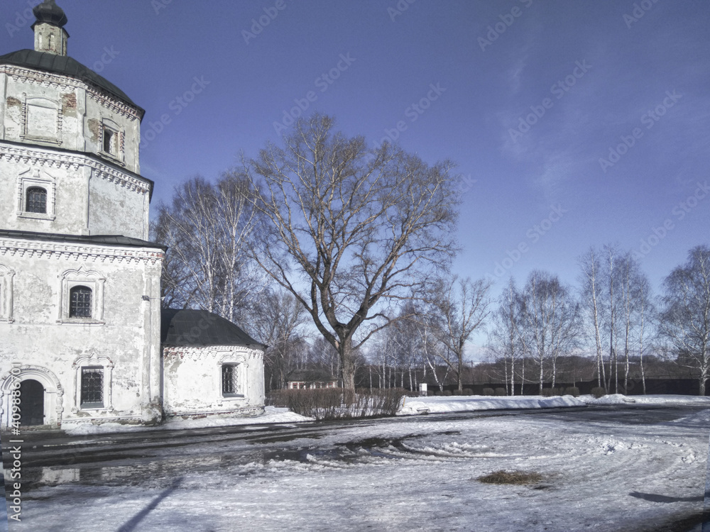 Old white сhurch in winter. An ancient chapel with worn walls in the village.