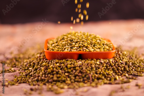 Falling Yellow moong dal, Indian pulse, yellow mong dal and green Moong bean with green mung daal on wooden table, healthy lentil pulse bean on table,falling moong dal on white bowl